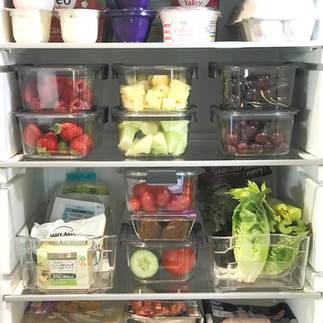 Organised fridge with shelve organised by food type and food stored in clear fridge containers