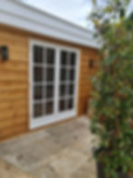 White French doors installed in a timber garden room.