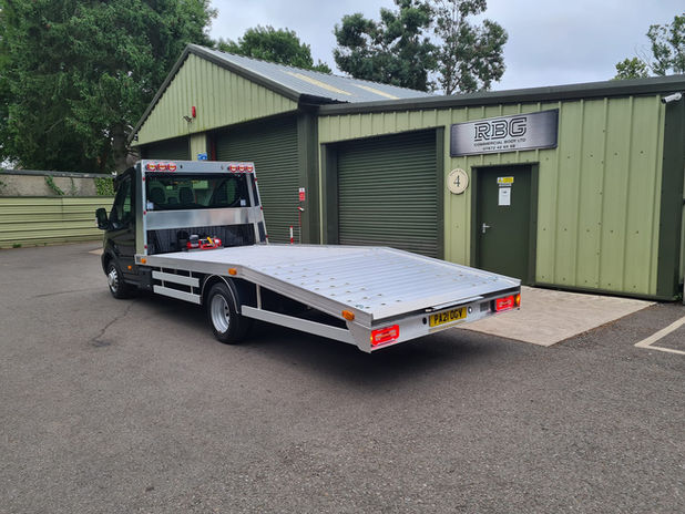 Back view of black flat back recovery truck