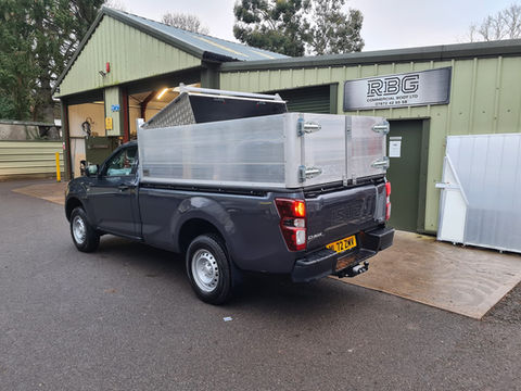 Side view of black 4x4 truck with aluminium high sides