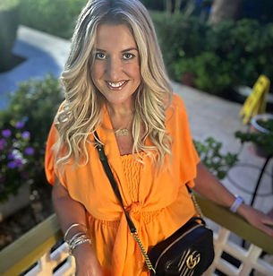 woman in orange top smiling at the camera