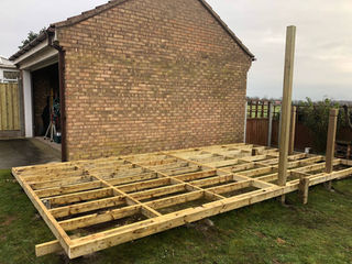 Construction phase of a structural timber framework for a garden deck
