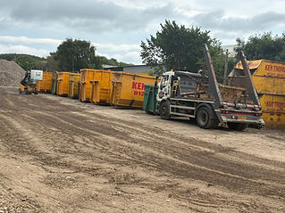 Row of skips in front of a truck trailer
