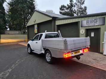Side view of modified white 4x4 truck with aluminium loading toolbox