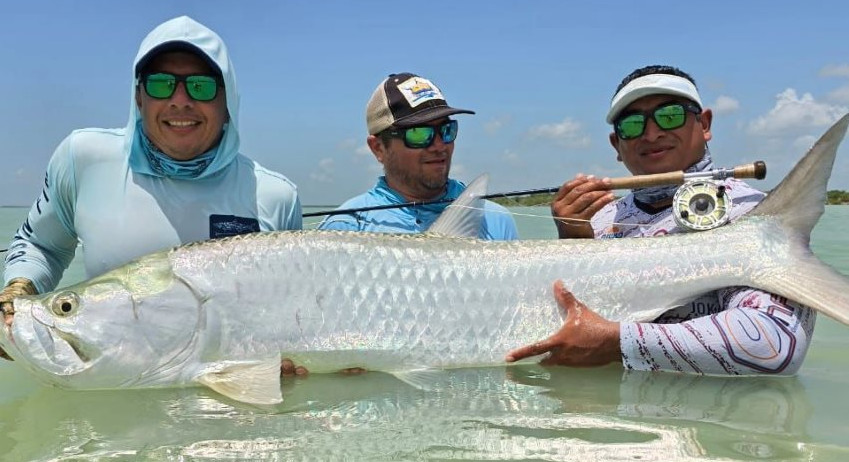 Happy Fly fisherman with an exceptional Tarpon