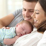 Close up portrait of a happy parents watching their baby sleeping on a bed at home_edited.