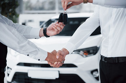 close-up-of-sales-manager-in-black-suit-selling-the-car-to-the-customer (1).jpg