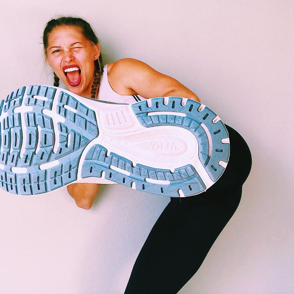 Fit woman trainer kicking into the camera