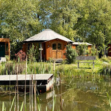 Yurts arranged around pont with jetty at retreat center in the Netherlands