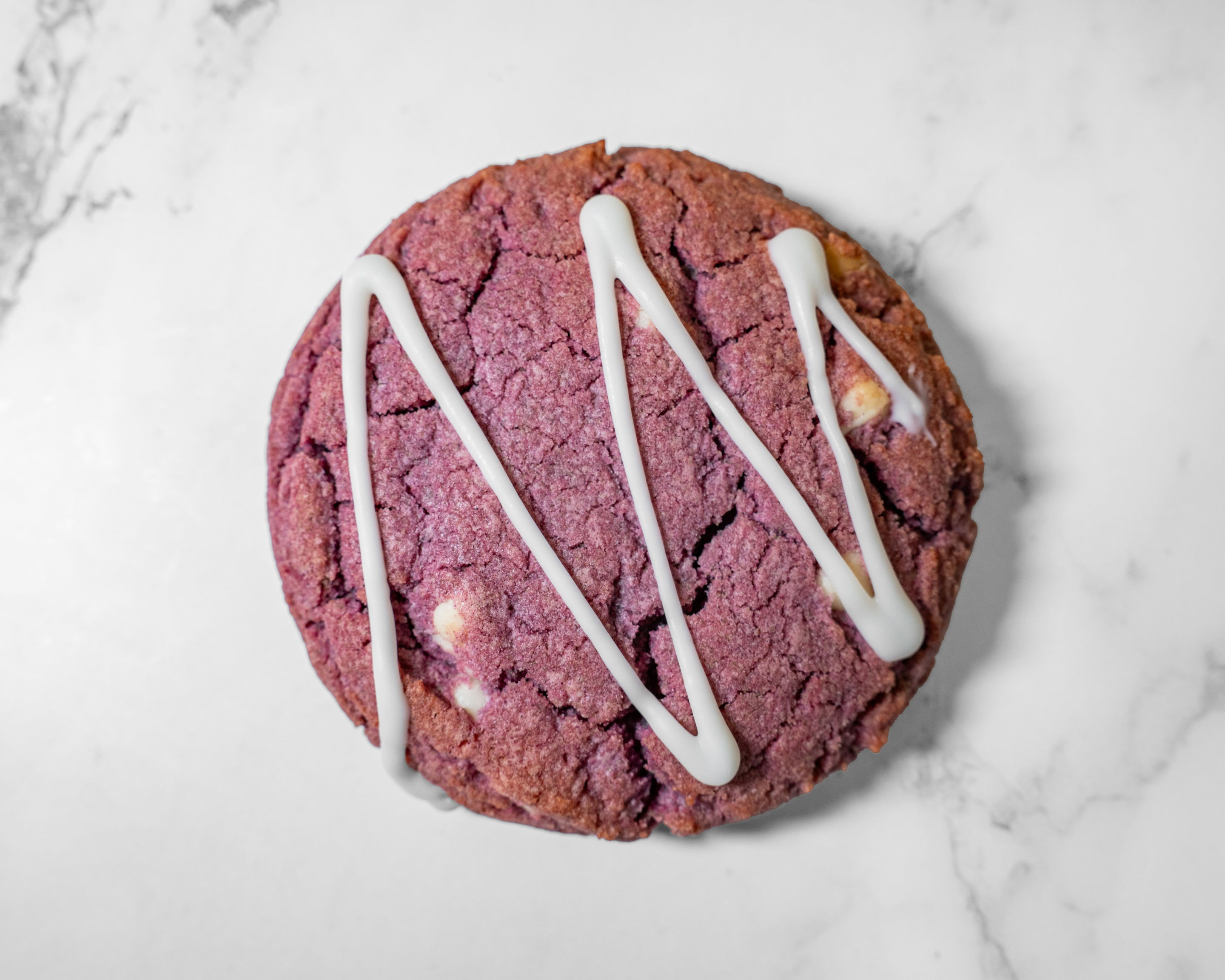 Ube Cookie made with white chocolate chips and a white chocolate drizzle