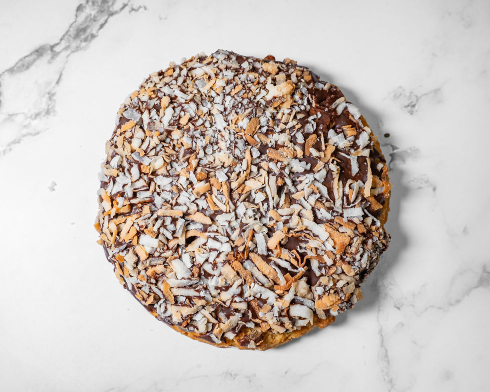 Chocolate chip cookie made with pecans and topped with toasted coconut flakes