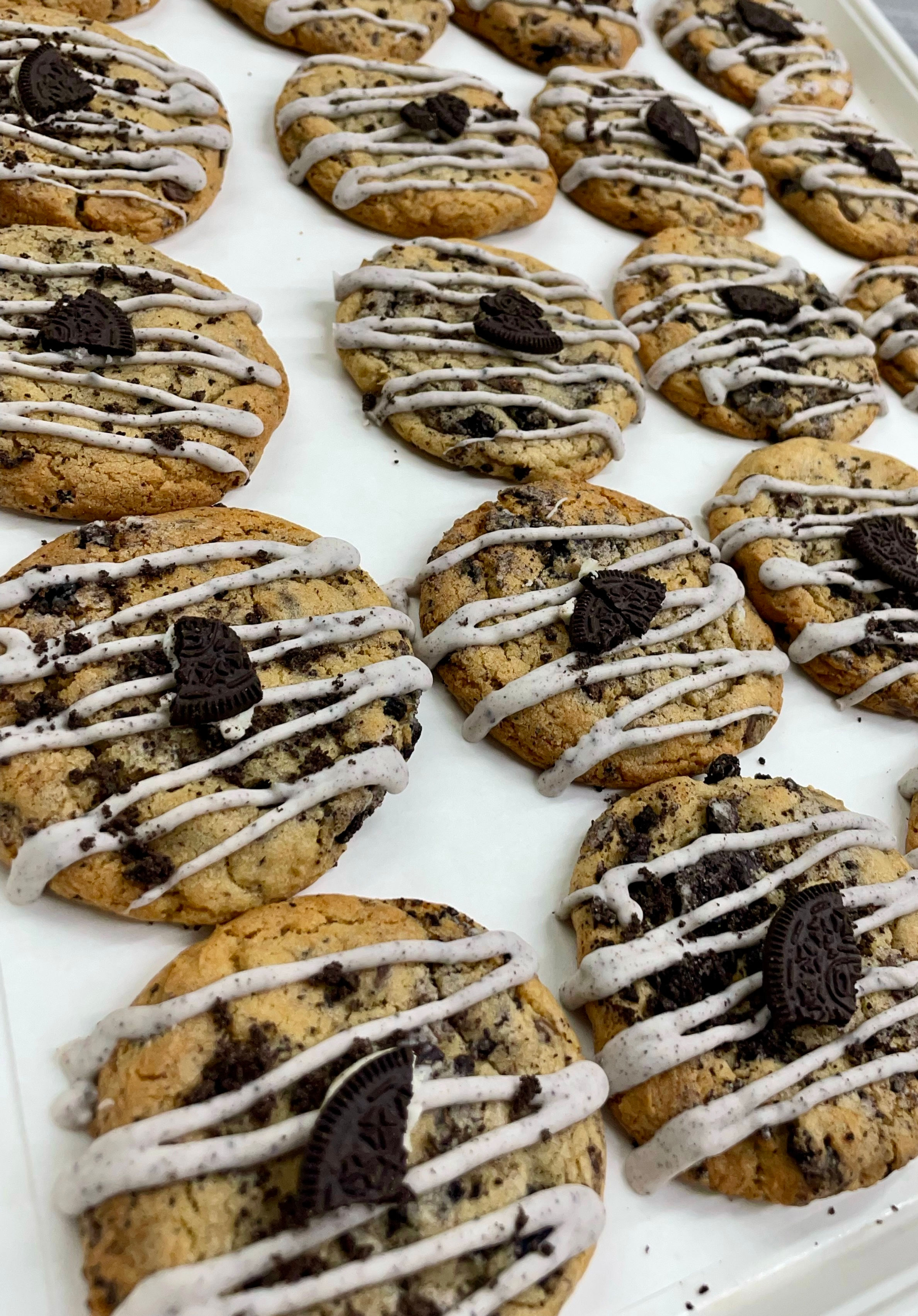 Soft cookies and cream cookie topped with cookie crumbs and drizzle