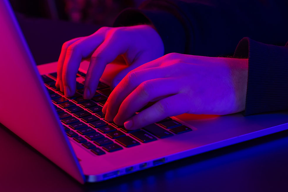 man-uses-laptop-closeup-male-hands-neon-lighting.jpg