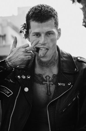 Norman Theuerkorn male model, editorial biker jacket, direct gaze, high contrast daylight outdoor
