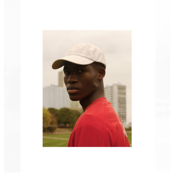 Man in red shirt and cap, urban background