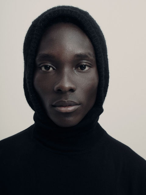 Portrait of a male model wearing a black turtleneck and hood