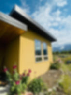 Yellow building with red flowers and mountains
