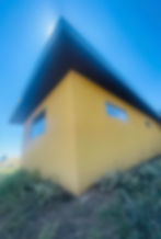 Modern yellow building with angled roof, blue sky