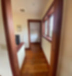 Interior hallway with wooden floors and dark wood trim