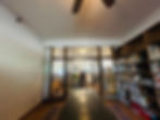 Library room with long table, bookshelves, open door