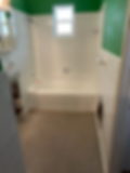 Before: Bathroom with green walls, white tile, and carpet