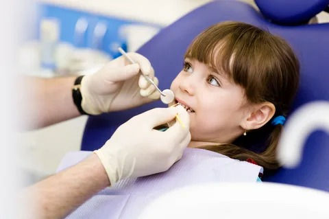  Pediatric dentist performing tooth-colored filling on child in Frisco