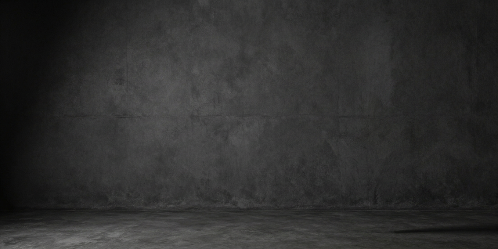 Studio photography of a dark, textured concrete wall and floor. The empty, minimalist space offers a neutral backdrop.
