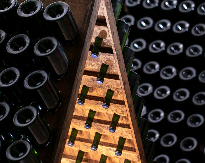 A wooden wine rack filled with lots of bottles