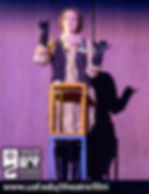 A woman behind a podium in futuristic garb