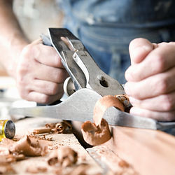 Un artisan passionné du Jura sculptant des objets en bois décoratifs, une expérience culturelle unique pour les amateurs d'art et d'histoire.