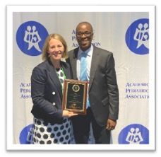Smiling woman and man with an award plaque
