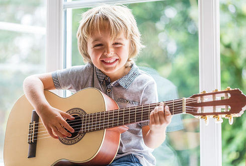 Happy smiling boy learning to play the a