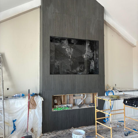 Modern custom fireplace finish installed by IHOMEU in Odessa, TX featuring large-format textured tile and contemporary design.