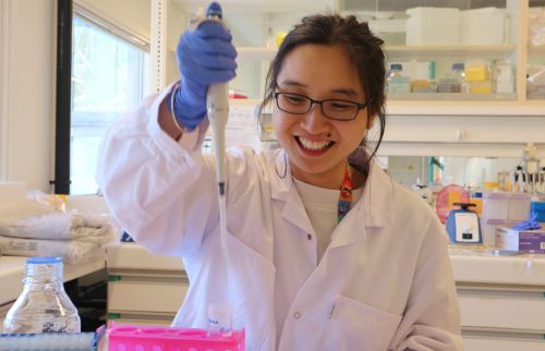 Picture of Pu Chen wearing a labcoat and holding a pipette.