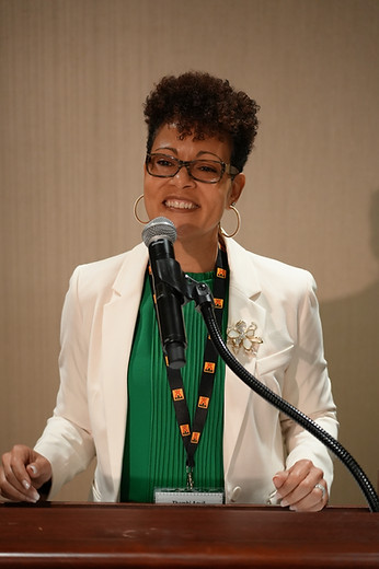 Sensible Living Coach founder, Dr. Thembi Aquil, speaking at a professional conference.