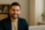 A professional digital photograph features a confident man seated on the far left side of a desk, smiling with a Nest Managers Real Estate laptop and documents in front of him, representing trusted Fayetteville property management expertise.