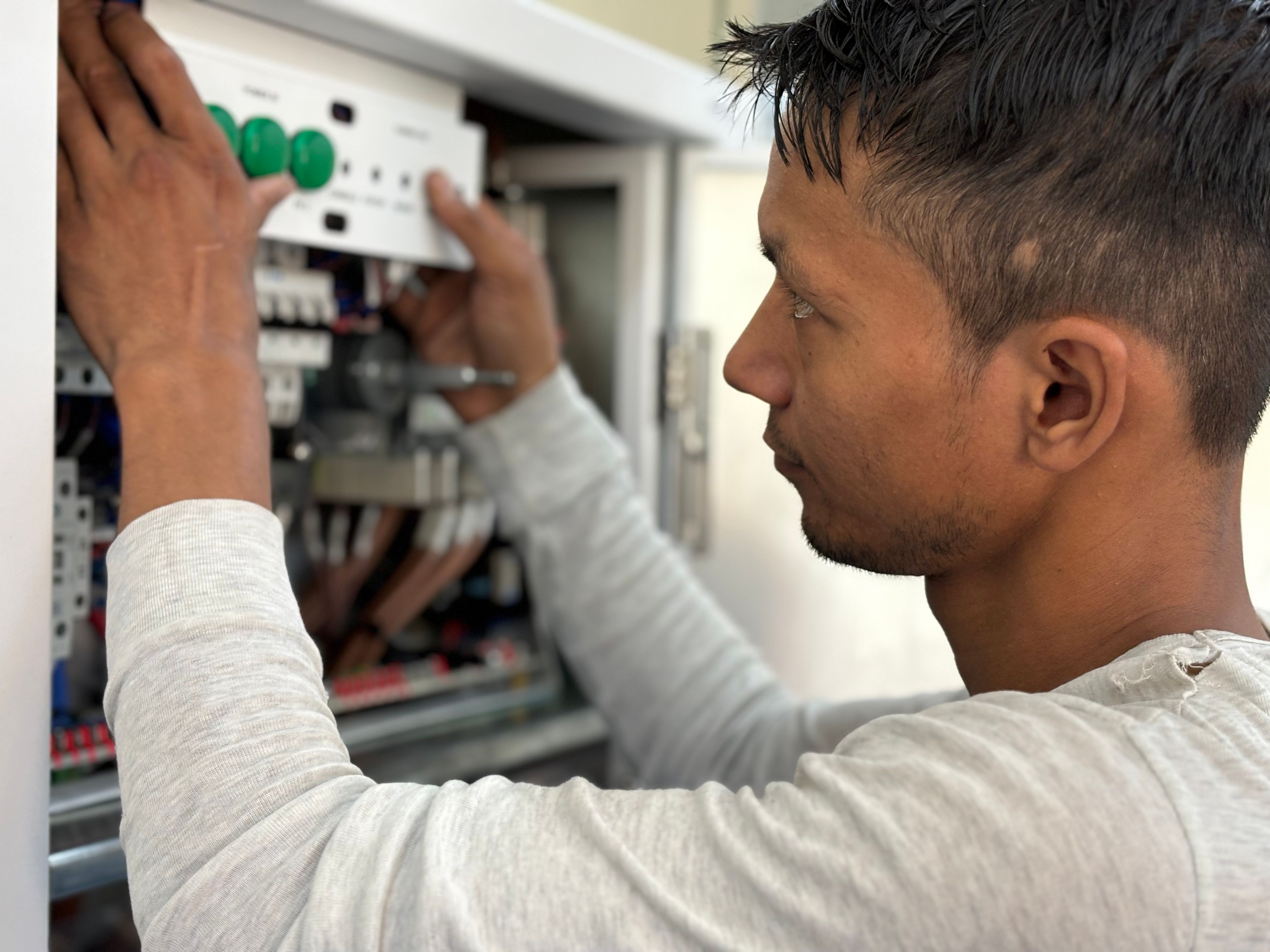 Elektriker arbeider ved et sikringsskap