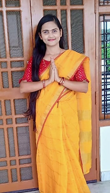 Foto Namrata Shahi, profesora de escuela de AYURYOGA latas. Viste una vestimenta tradicional industrial de color amarillo, similar a un pañuelo que la cubre como falta y luego sube sobre el hombre. Su pelo es de color castaño ósculo y su tes blanca. sus manos se encuentran en postura de oración. Ella sonríe