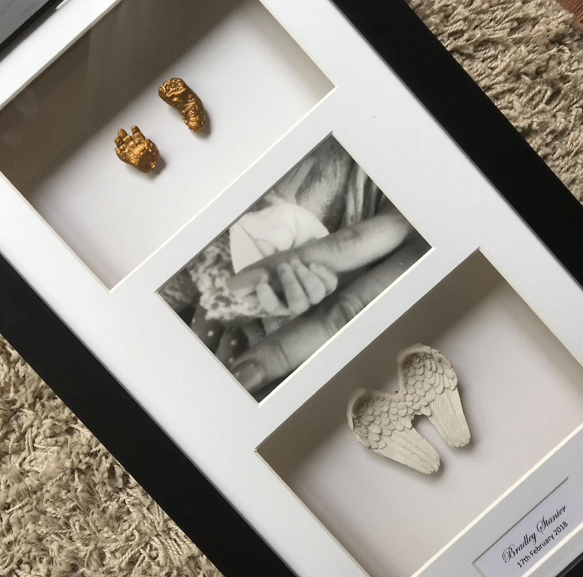 Our memorial and bereavement casting varies this is of an angel babies hand and foot casting, photograph and ceramic angel wings all displayed separately in a custom 3 window box frame.