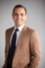 Joseph Rome, Sequor Law attorney, professional headshot in tan blazer with navy tie