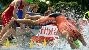 Teilnehmer eines Aquathlon-Wettkampfes beim Sprung ins Wasser im Schwimmbad Knittelfeld während der steirischen Landesmeisterschaft.