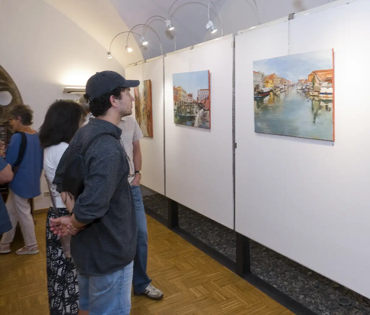 Besucherinnen und Besucher betrachten die ausgestellten Ölbilder von Julia Bauernfeind im Forum Rathaus Knittelfeld.