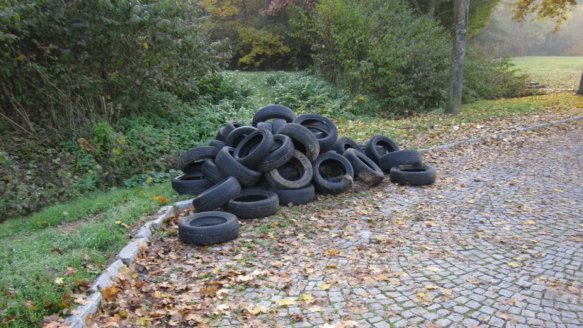 Autoreifen liegen illegal entsorgt auf einem Parkplatz