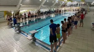 Schülerinnen und Schüler stehen beim Schulteamschwimmen der Bildungsregion Murau-Murtal im Knittelfelder Hallenbad entlang des Beckens vor dem Wettkampf.