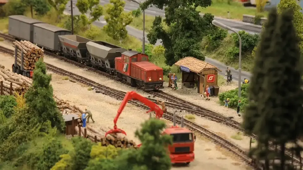 Güterzug auf der Modellbahnanlage Knittelfeld mit Holzverladung, Figuren und landschaftlicher Detailgestaltung.