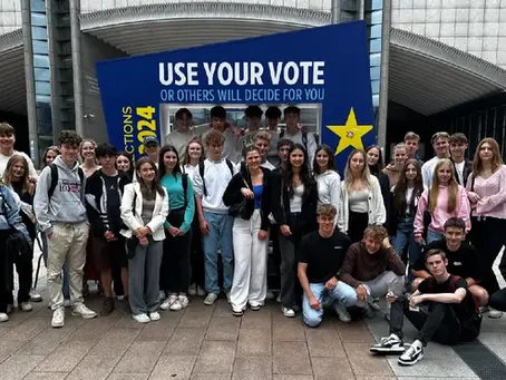 Gruppenfoto von Schülerinnen und Schülern des BG/BRG Judenburg vor dem Europäischen Parlament in Brüssel bei einer Erasmus+ Reise mit dem Slogan „Use your vote“ im Hintergrund.