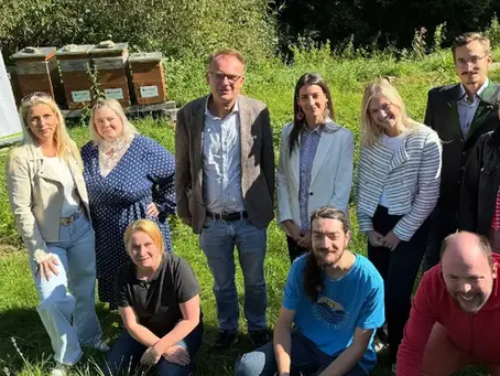 Vertreterinnen und Vertreter von Lebenshilfe Region Judenburg und Magna stehen am Kohlplatz vor den Bienenstöcken.