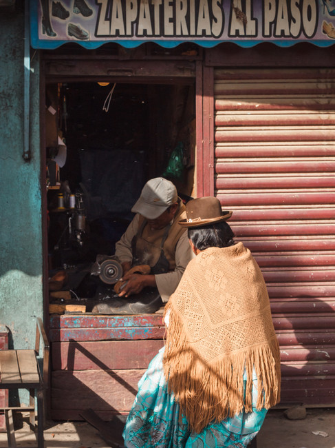 Una cholita da un calzolaio al mercato di El Alto, La Paz