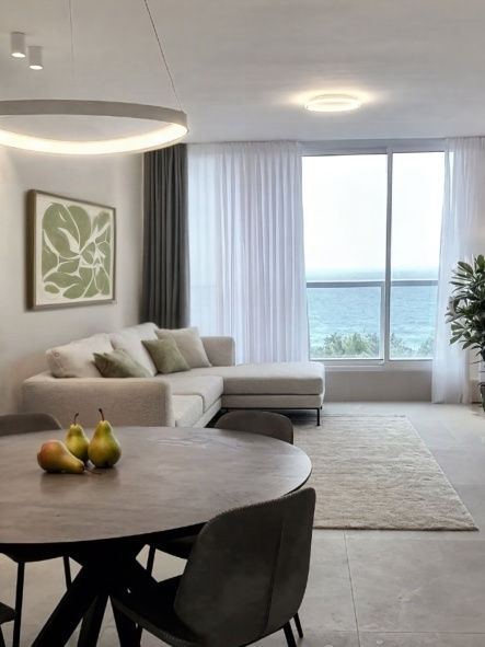 חלל מגורים מואר עם וילונות בהירים ופינת ישיבה אלגנטית