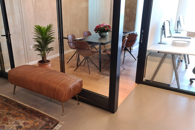 חלל עבודה עם מדפי עץ פתוחים ורצפת פרקט בהירה